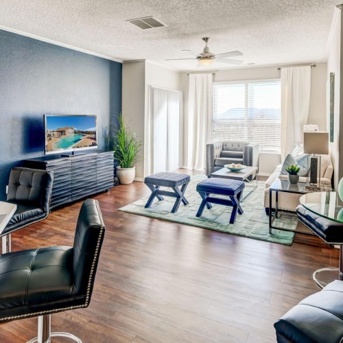 a living room with a tv, tables and chairs